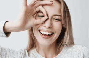 portrait of beautiful joyful blonde female smiling with fingers in okay gesture.