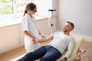 Medical provider providing IV therapy to happy patient.