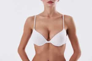 Woman wearing a white bra with full breasts after breast augmentation in Dallas