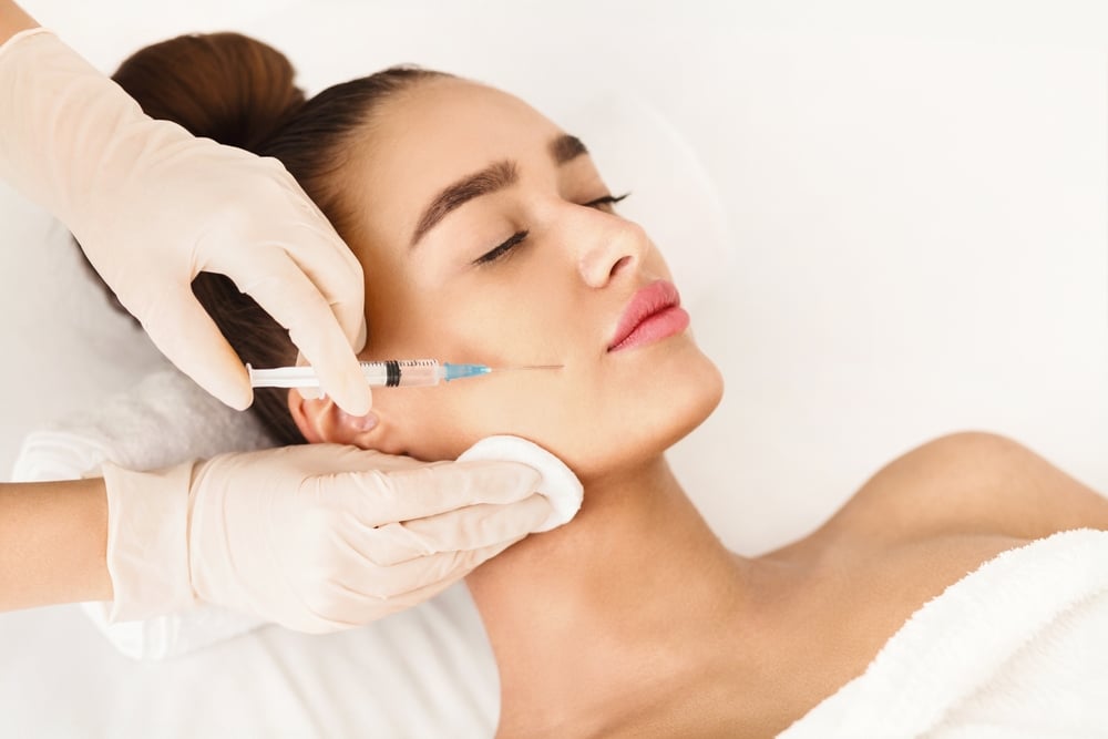 Relaxed woman getting Sculptra injections in her face in Dallas, TX